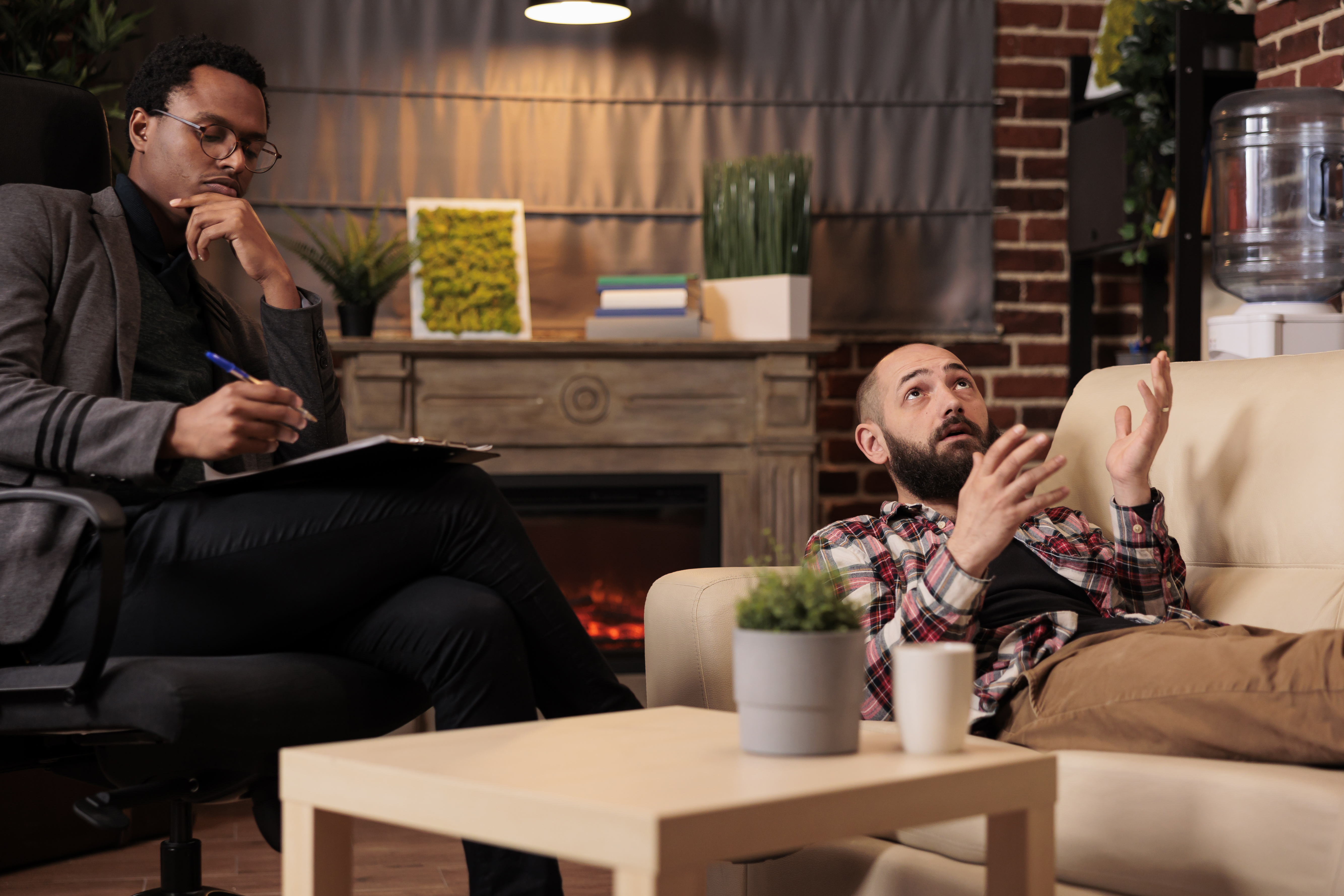 African american psychologist consulting man laying on couch
