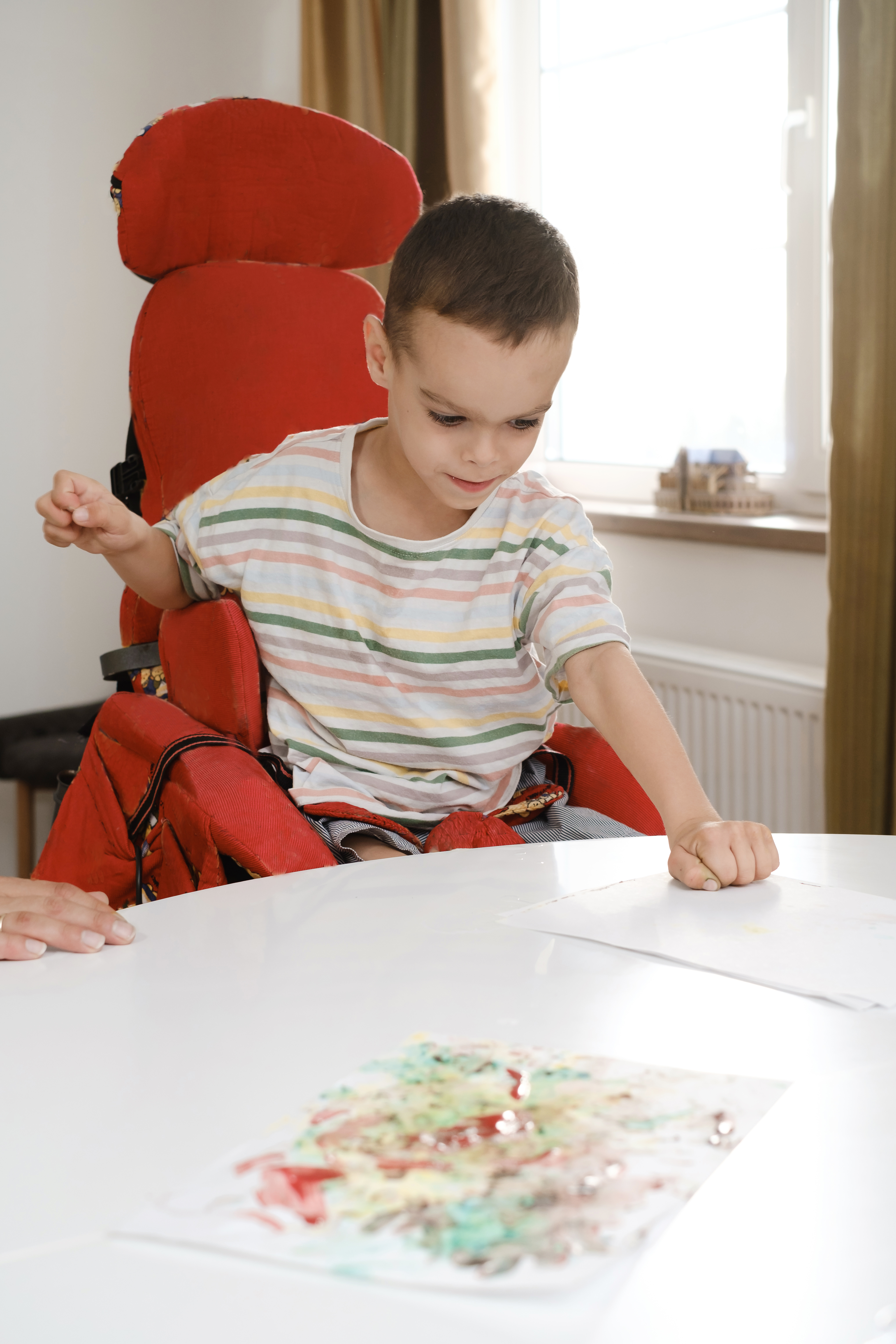Child with cerebral palsy painting, mental physical disorders art therapy
