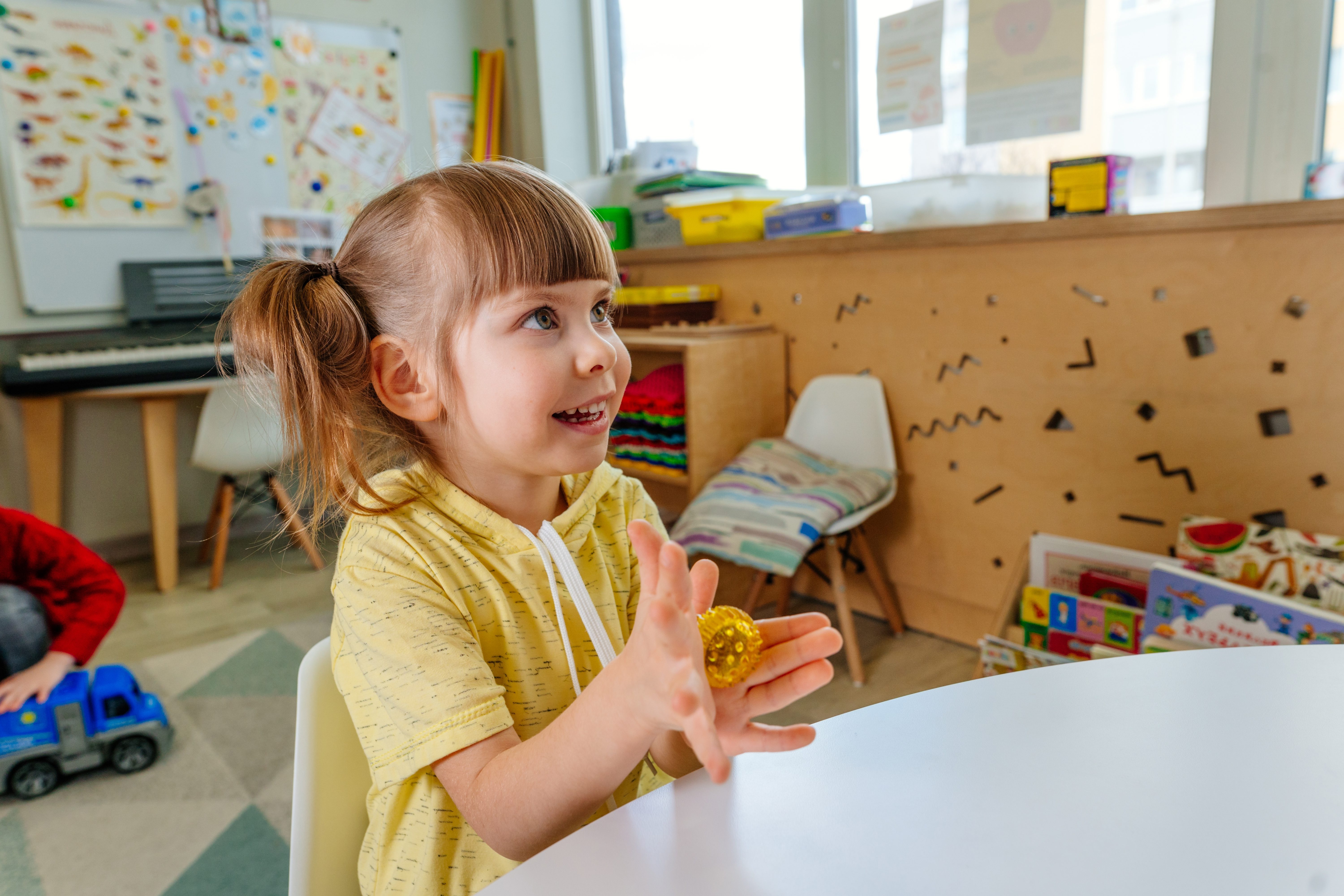Girl on the lesson of the development of fine motor skills in kindergarten