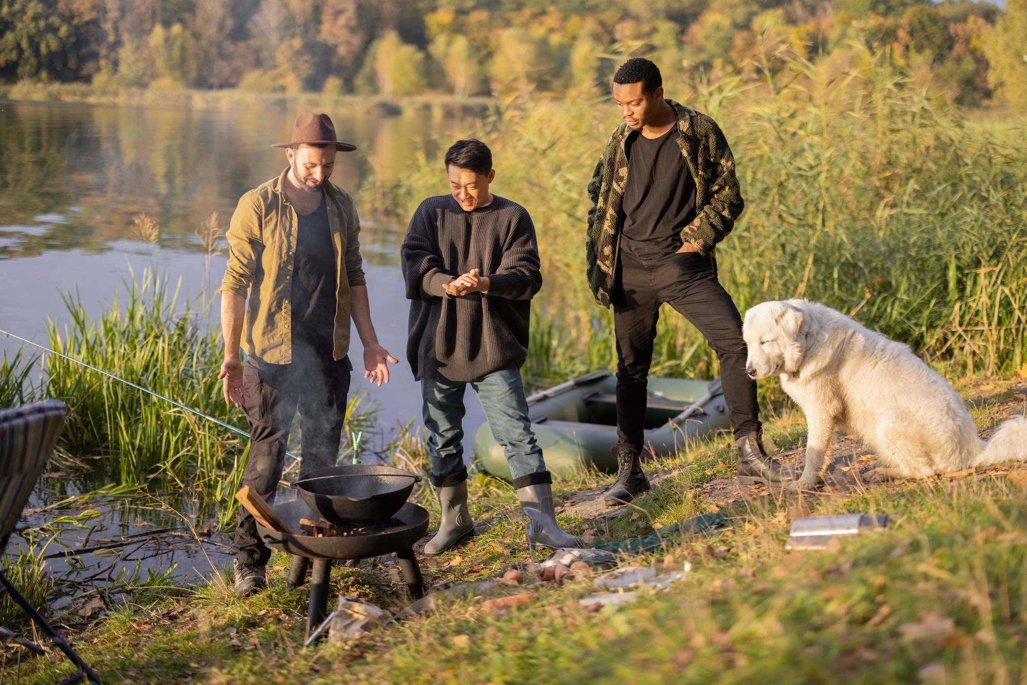 Multiracial group of male friends talking and cooking Ukha on fire